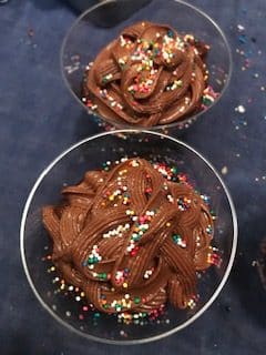 chocolate frosted cupcake in cup with sprinkles