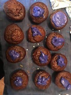 blobs of purple frosting divided among the cupcakes
