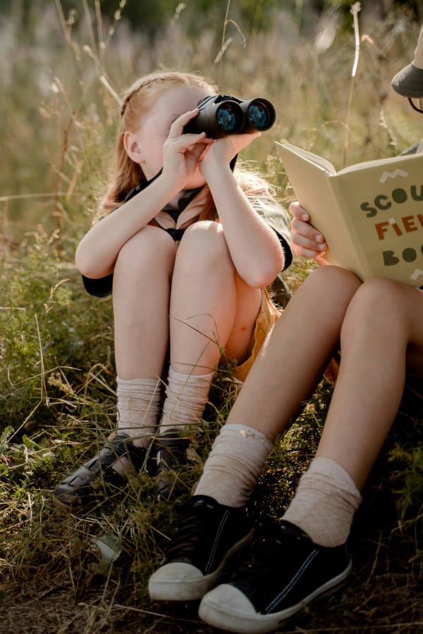kid with binoculars in field