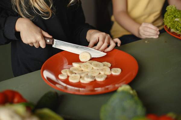 kid slicing banana