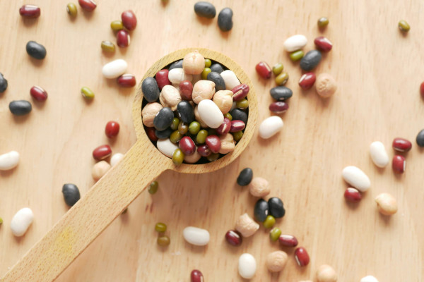 wooden tablespoon full of colorful beans