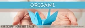 blue origami swan held in two hands.