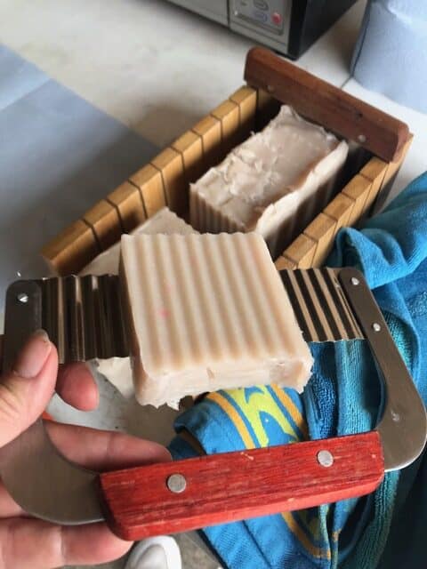 slice of soap on wavy cutter with cutting block