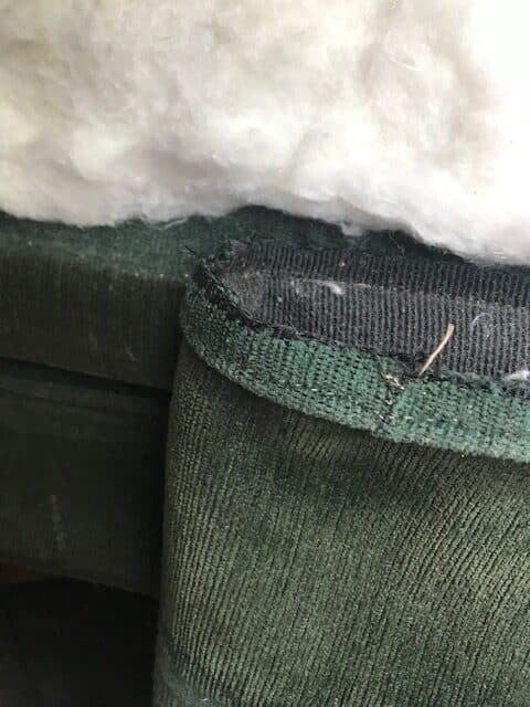 close up upholstery fabric with piping being removed