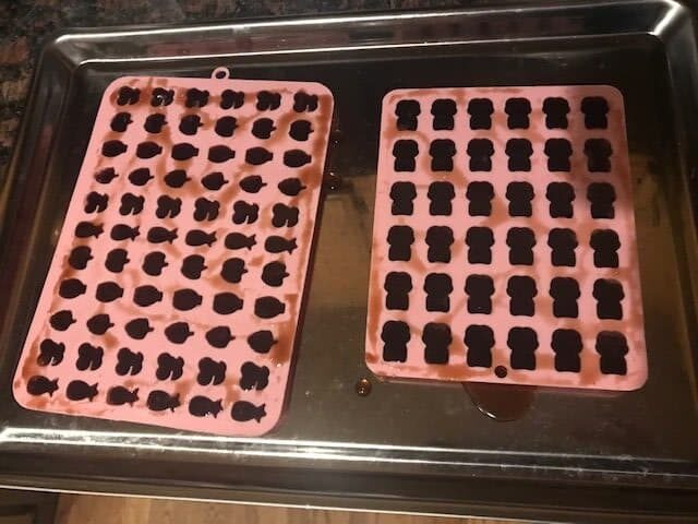 two silicone molds filled with elderberry gummies