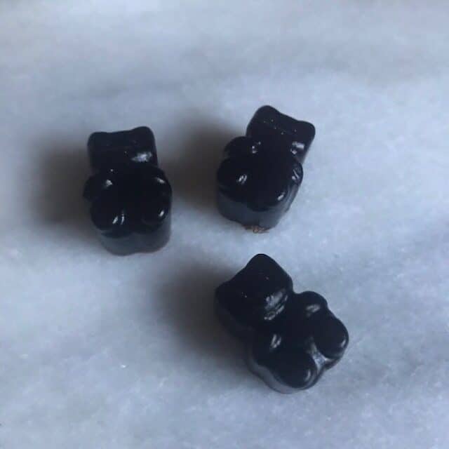 close up of 3 elderberry gummies on marble slab